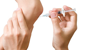 PRP injection being injected into an elbow joint.