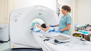 Technician assisting a patient through a CT scan