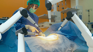 A surgeon performing a surgery with the help of several robotic arms.