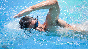 Man swimming freestyle in a pool.