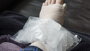 Ankle wrapped in bandage with ice on the joint.