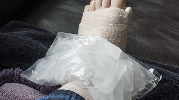 Bag of ice on wrapped foot wrapped with bandage
