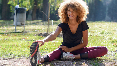 Woman doing a forward fold at the park