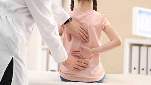 Young girl having her spine examined by a doctor.