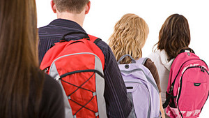 Adolescent high schoolers carrying backpacks.