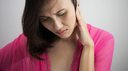 Woman holding the side of her head and neck in pain