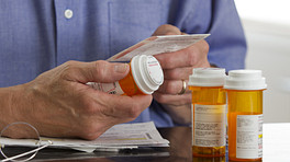 Person reading the label on a prescription pill bottle