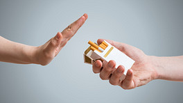 Hand saying no to a pack of cigarettes.