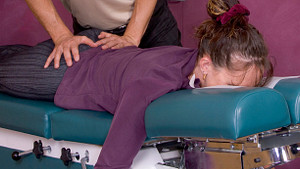 Chiropractic adjustment being applied to the lower back.