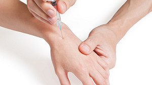 Needle being injected into a hand.