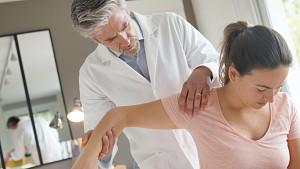 Therapist stretching patient's shoulder.
