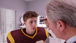 Ddoctor checking a patients eyes for a concussion