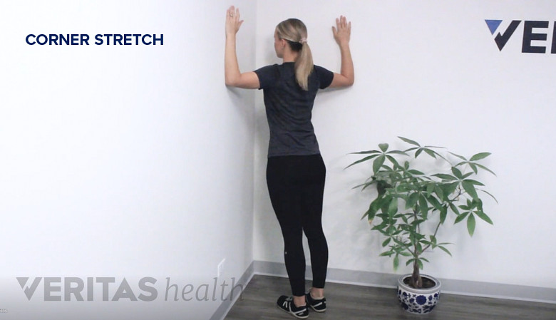 Therapist showing corner stretch exercise.