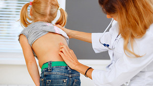 Doctor examining young patient&#039;s spine