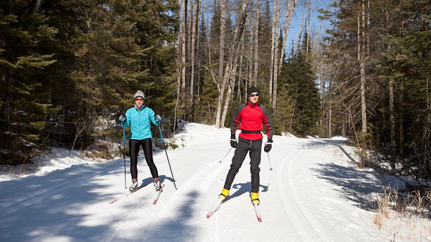 Couple skiing down a trail