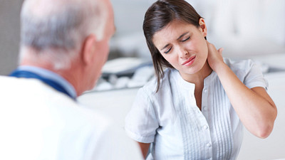 young woman with neck pain at doctor consultation