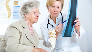 Paciente mayor revisando rayos x con un médico