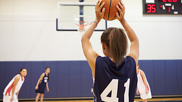 Girl shooting a free throw on a basketball court.