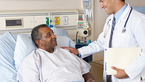 Doctor speaking with a patient in a hospital bed.