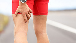 跑步者抓住他们的脚筋疼痛。