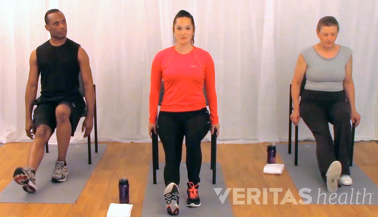 three people performing seated hamstring stretch for sciatica from a herniated disc