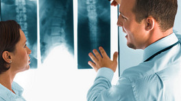 Doctor examining an X-ray of a patient&#039;s spine.
