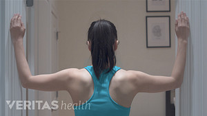 Woman performing the corner stretch for neck pain