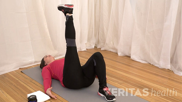 Woman performing the supine leg raise stretch