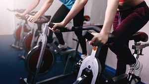 Woman and man riding stationary bikes in the gym