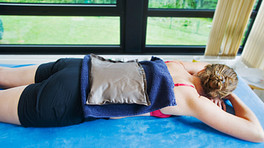 Woman lying prone with heating on their back