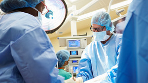 Surgeons performing surgery in the operating room.