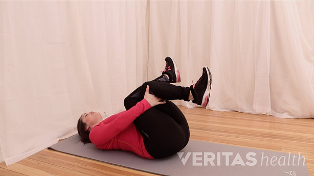 Woman lying on the floor doing the supine piriformis muscle stretch
